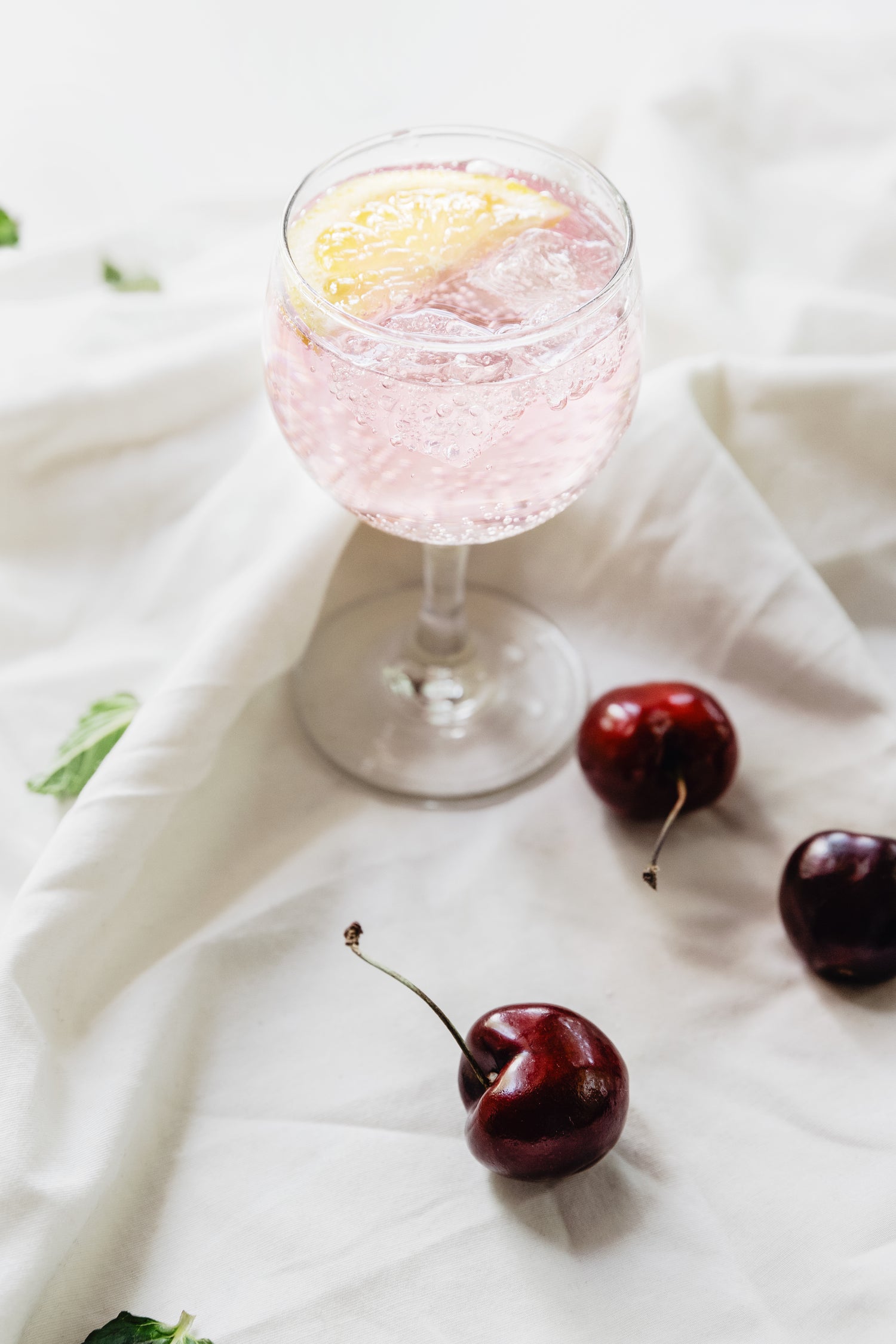 sparkling drink and cherries on fabric