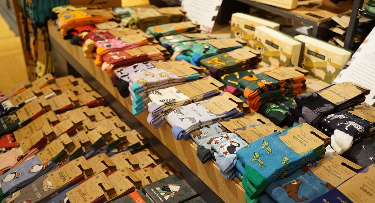 Display of various pairs of socks on a wooden rack in a store.