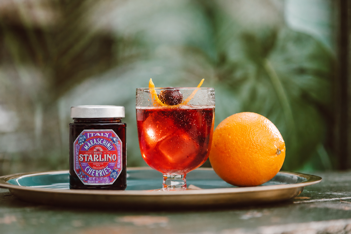 Hotel Starlino jar beside an orange cocktail on a tray